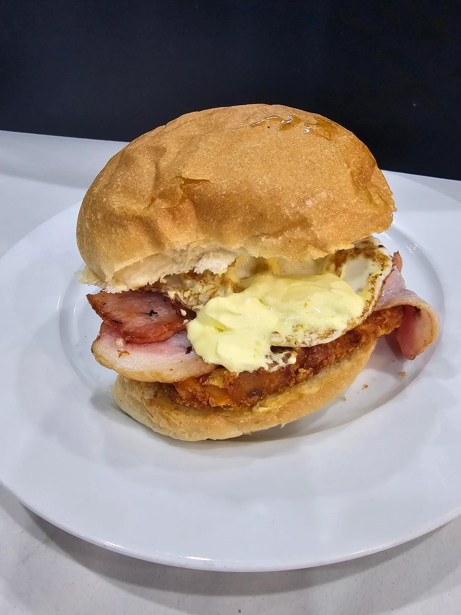 Chicken schnitzel burger with bacon, egg and aioli