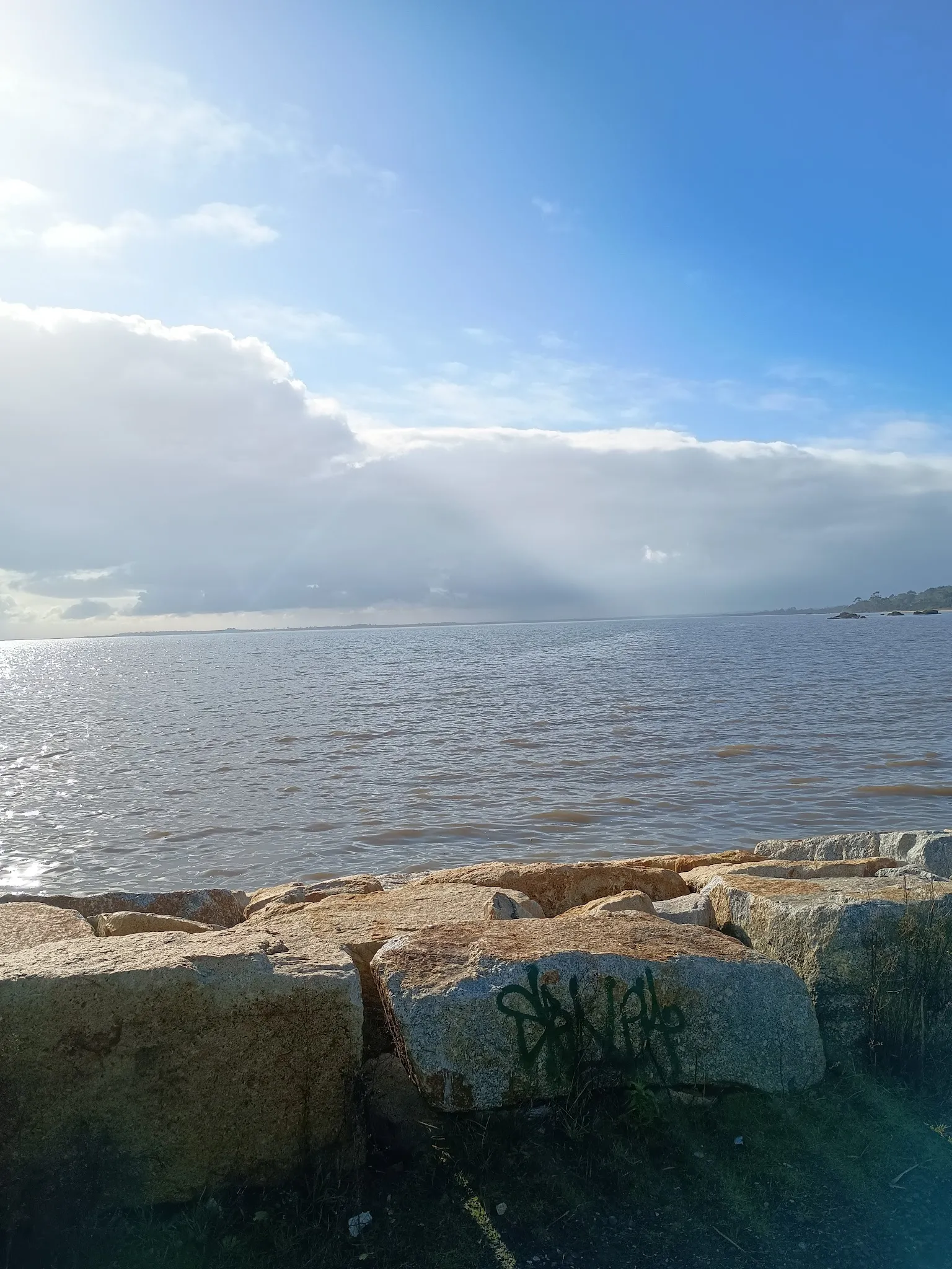 Shimmering bay waters with sandstone boulders near the Grantville coast
